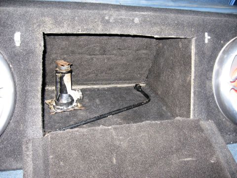 1996 Ford Bronco - This image shows a storage compartment within a vehicle, containing a jack and a tire iron.