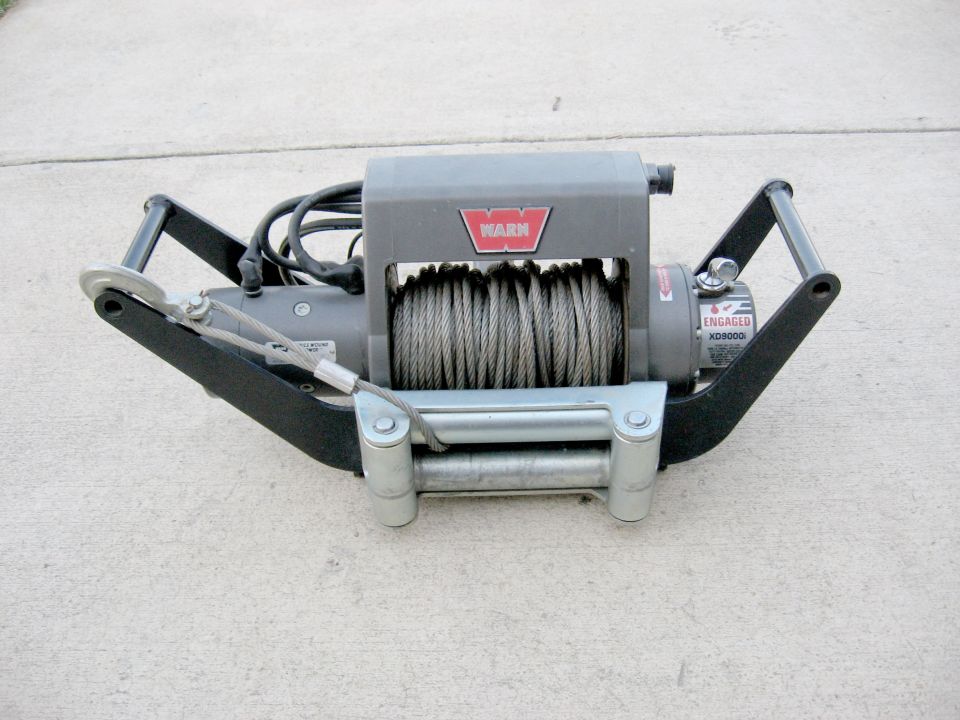 Warn XD9000i winch with steel cable and roller fairlead on concrete