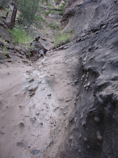1984 Ford Bronco - A natural scene of a dry creek bed winding through a rocky canyon with sparse vegetation.