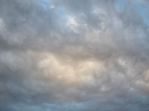 1984 Ford Bronco - The sky is filled with dark, dramatic clouds, hinting at an approaching storm.