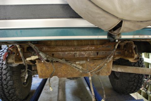 1996 Ford Bronco - The rear undercarriage of a vehicle, a rusty fuel tank and exposed wiring.