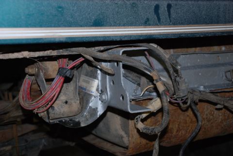 1996 Ford Bronco - Close-up of the rear bumper mounting bracket on a 1996 Ford Bronco, revealing a Ford logo sticker and wiring harness.