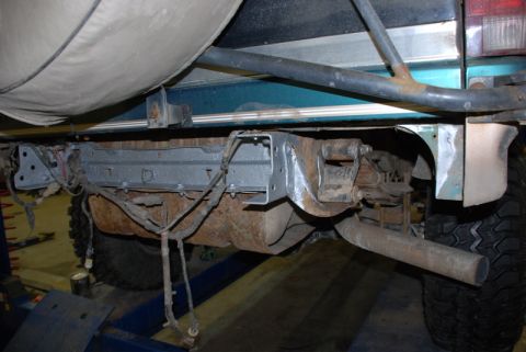 1996 Ford Bronco - Underside view of a vehicle's rear bumper assembly and suspension components, with visible rust and wiring.