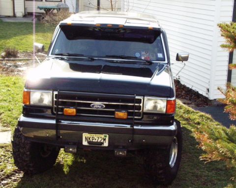 1989 Ford Bronco - This black Ford Bronco, likely from the late 1980s, is parked in a residential driveway.