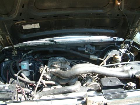 1992 Ford Bronco - The engine bay of a vehicle is shown with various hoses and mechanical parts.