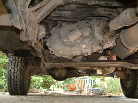 1992 Ford Bronco - The underside of a vehicle, revealing its drivetrain and a tire, with visible text from Supermotors.net.