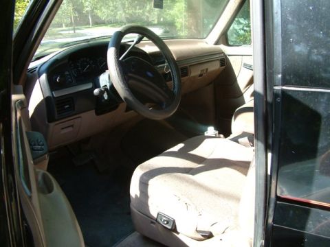 1992 Ford Bronco - The interior of a 1992 Ford Bronco, its dashboard, steering wheel, and worn driver's seat.