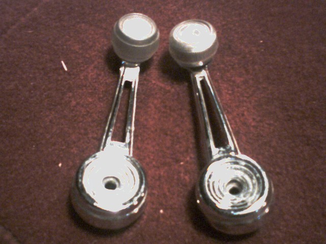 Two chrome window crank handles with black knobs
