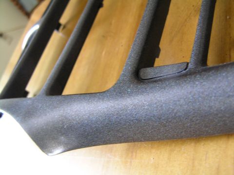 1993 Ford Probe - A textured plastic trim piece, likely from a car's interior, is shown against a wooden background. The Supermotors logo is visible.