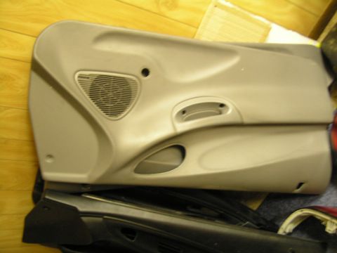 1993 Ford Probe - A tan car door panel is shown with a speaker grille and a storage compartment.