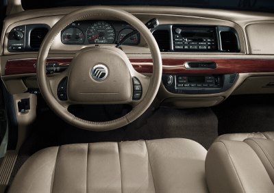 2003 Mercury Marquis - The interior of a 2003 Mercury Grand Marquis features tan leather seats and a wood-grain accented dashboard.
