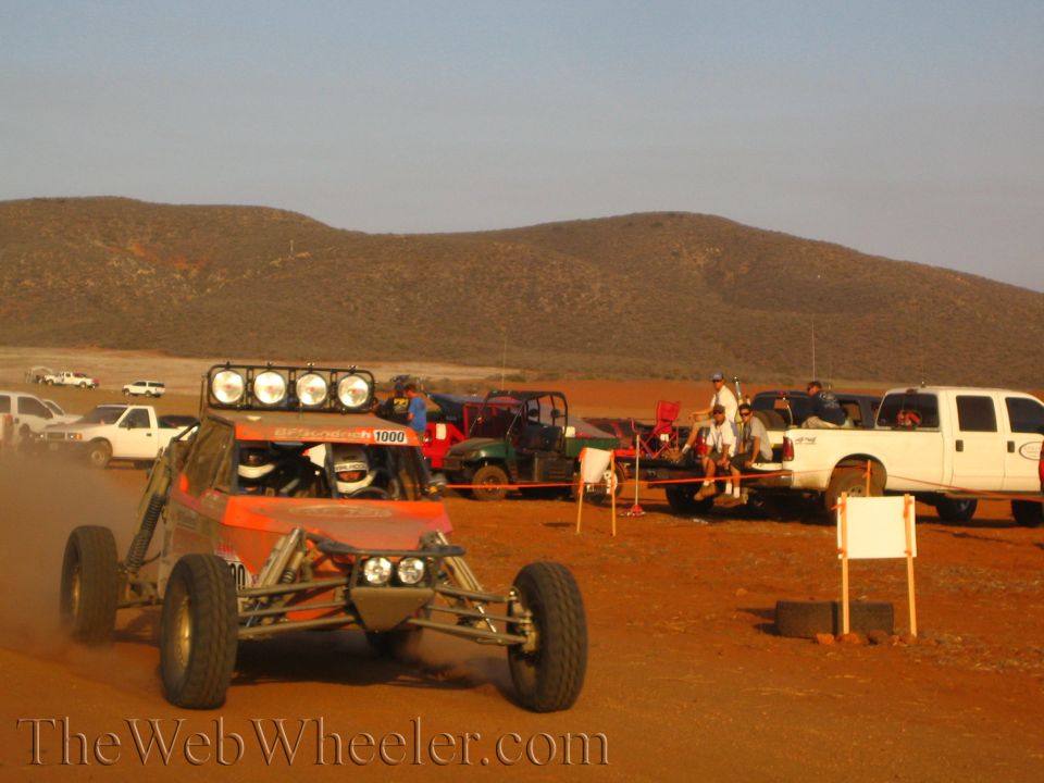 Number 1009 off-road buggy with roof light bar on dusty desert pit road