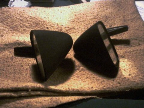 1973 Ford Ranchero - Two black side mirrors are displayed on a textured surface, possibly for sale or repair.