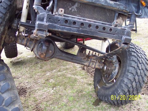 1984 Toyota 4Runner - Close-up view of the front axle and suspension system on a heavily modified off-road vehicle.