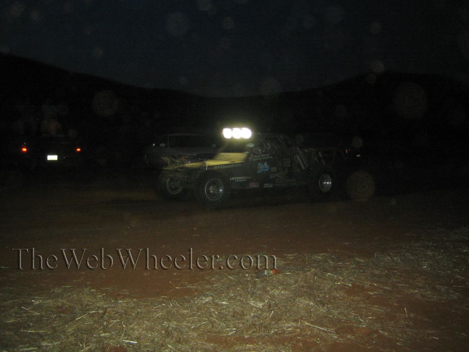 Yellow off-road race buggy with lit light bar at night in the desert