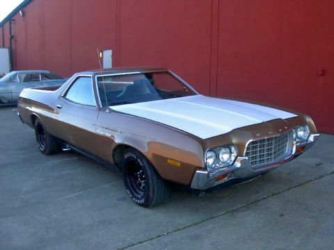 1972 Ford Ranchero - A brown and white 1972 Ford Ranchero is parked in front of a red wall, with another car visible in the background.
