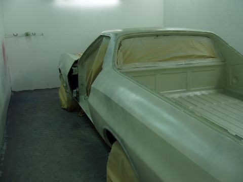 1972 Ford Ranchero - A 1972 Ford Ranchero is prepped for paint in a booth, showing its primer finish and open driver's door.