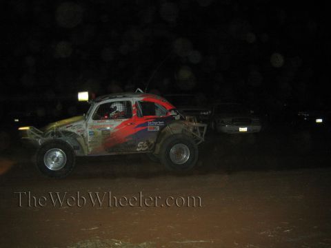 1990 Ford Bronco - Volkswagen-style Baja Bug race car with red and blue graphics and number 55 races at night on a dirt course.