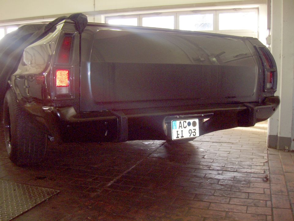Dark 1972 Ford Ranchero rear view, partially covered, with a license plate reading AC EI 93