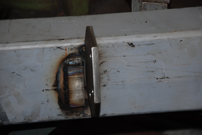Welded metal bracket attached to a gray frame section