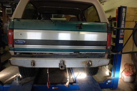 1996 Ford Bronco - The rear of a Ford Bronco is shown on a vehicle lift in a garage.