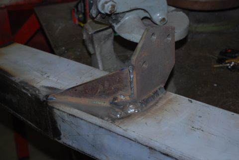 1996 Ford Bronco - A custom metal bracket is welded onto a larger metal frame, showing the fabrication process.
