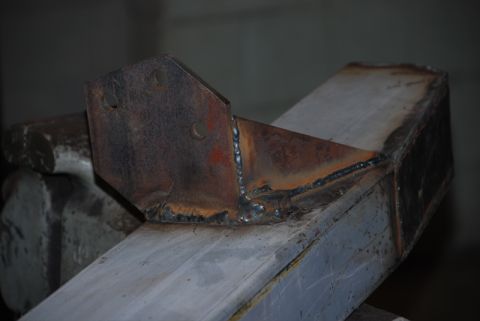 1996 Ford Bronco - A close-up view of a fabricated metal bracket, likely a custom part, with visible welding and signs of rust.