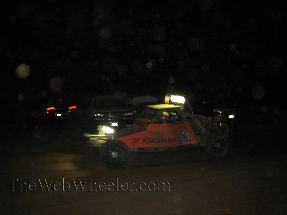Orange Yokohama number 1603 off-road race buggy at night on dirt