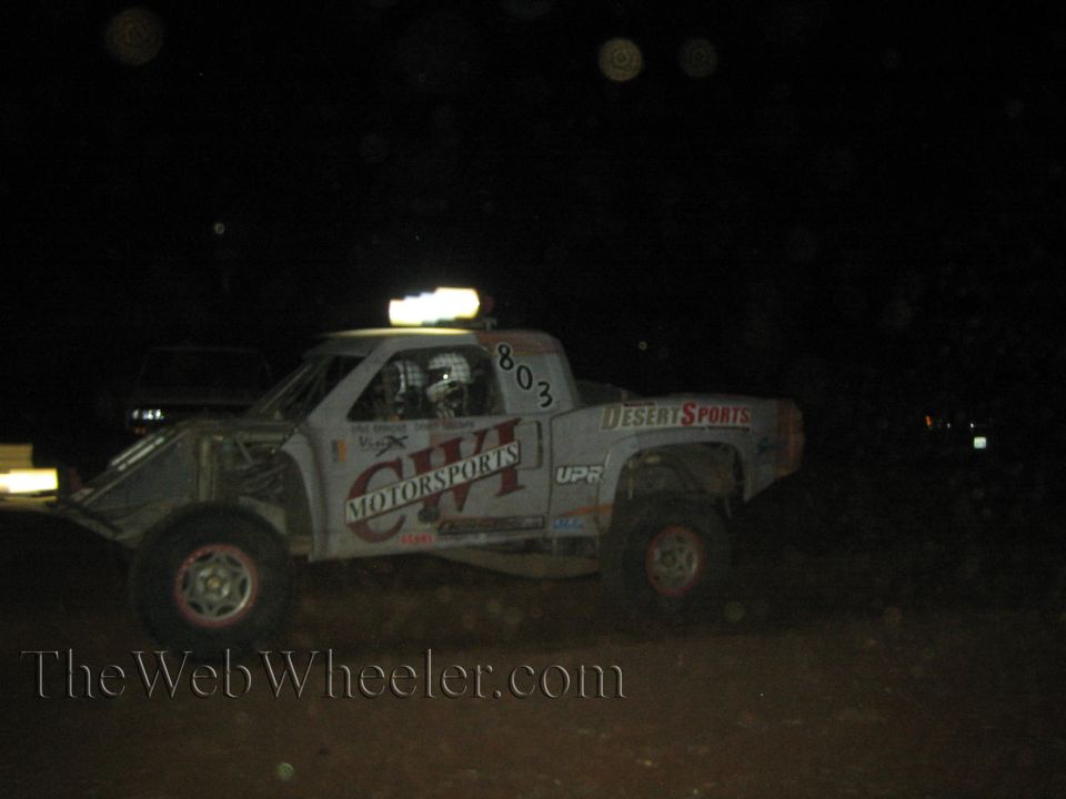 White CVI Motorsports number 803 off-road race truck at night