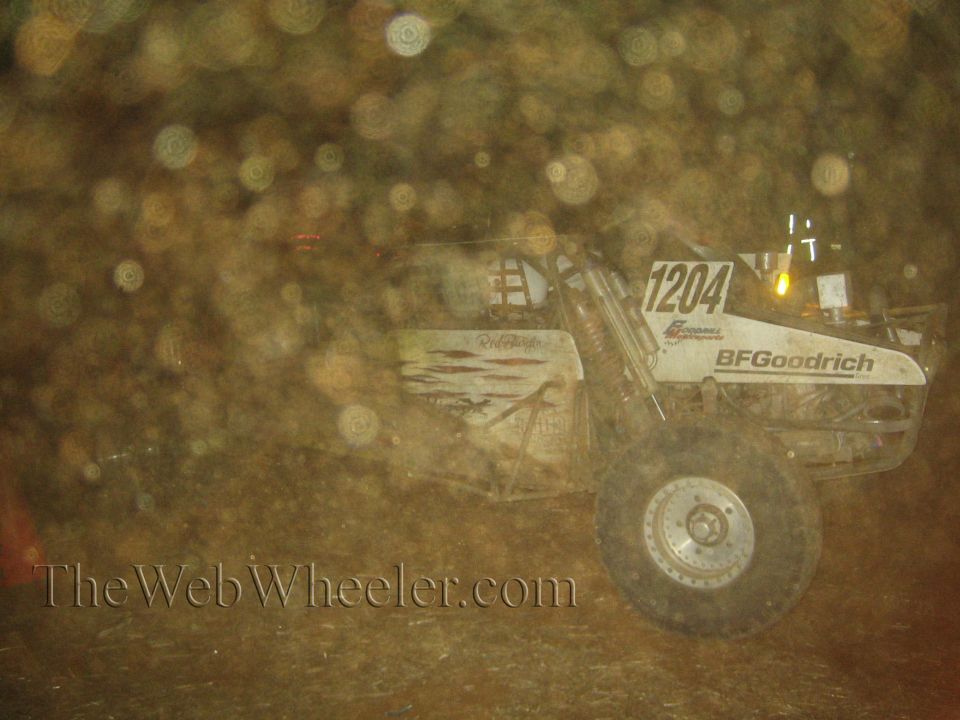 White number 1204 off-road buggy with BFGoodrich decal at night in dust