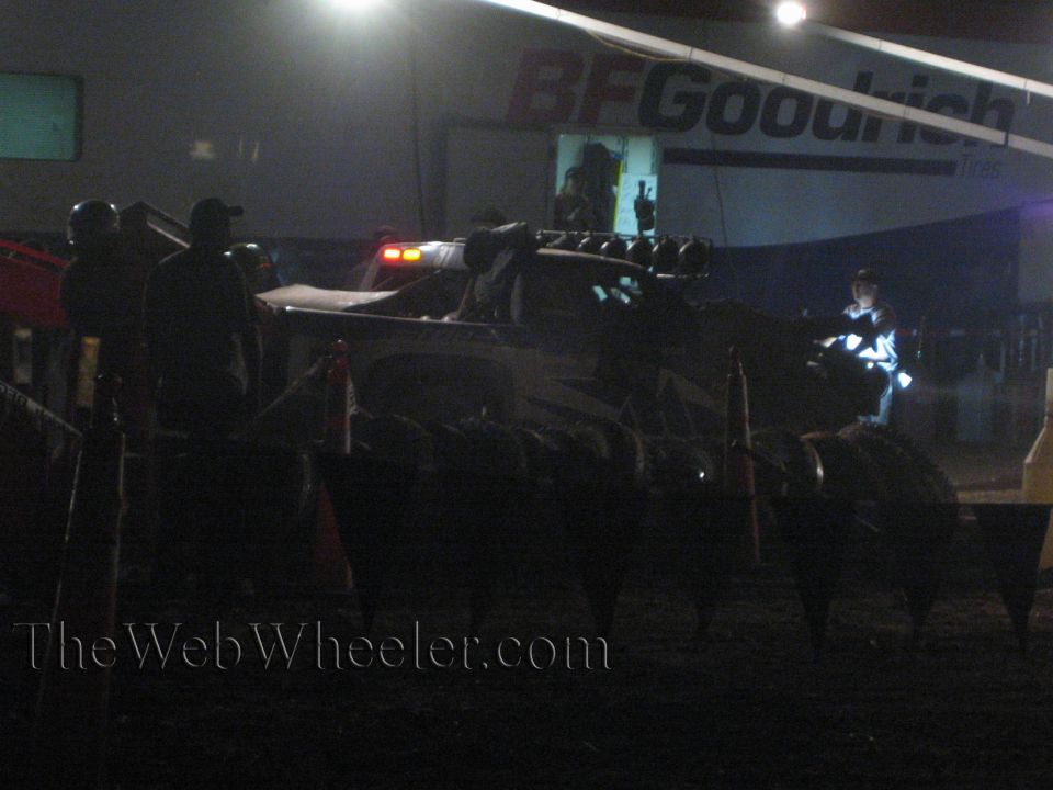 Off-road race truck in pit at night with crew under BFGoodrich banner