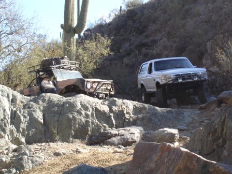 1993 Ford Bronco - Two modified SUVs, including a 1993 Ford Bronco, tackle a challenging rocky off-road course.