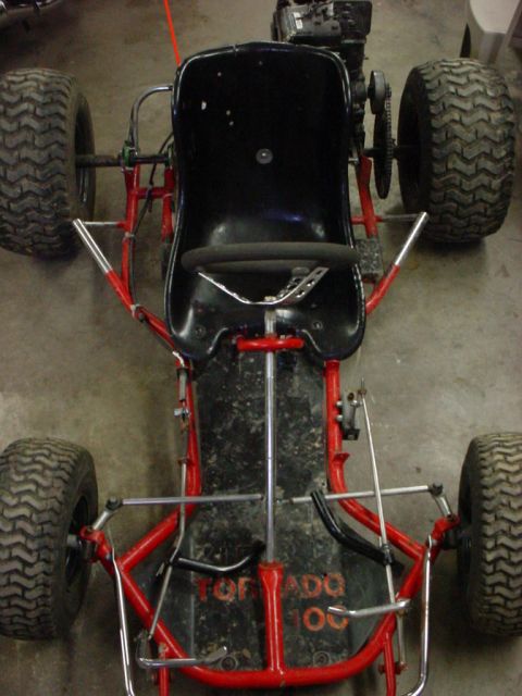 1990 Ford Bronco - This go-kart has a red frame and a black seat, with "TORNADO 100" visible on the floor pan.