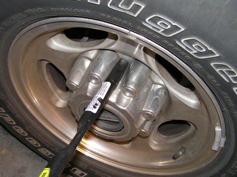 2000 Ford Excursion - Pry off the lug nut wheel cover.