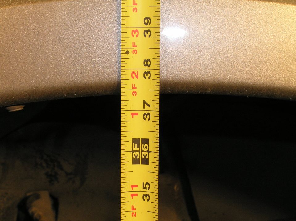 Before jacking up the front end, I measured the height from the ground to the top of the wheel well. You may want to do this too so you can compare the height after you install the V-Codes.

Stock Excursion leaf springs before the spring swap created 37.5" from the ground to the top of the wheel well. (After the V-codes were installed, this was increased by 1.5" to a total height of 39"!).