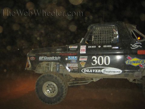 Black number 300 off-road race truck racing at night