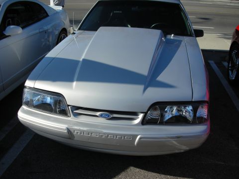 1998 Ford Crown Victoria - A silver Ford Mustang is parked in a lot next to another vehicle.