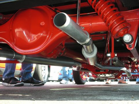 1998 Ford Crown Victoria - Undercarriage view of a show car with a glossy red rear axle, coil-over spring and polished exhaust pipe.