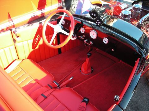 1998 Ford Crown Victoria - Custom hot rod interior with red upholstery, a white four-spoke wheel, round gauges and a fuzzy-dice shifter.