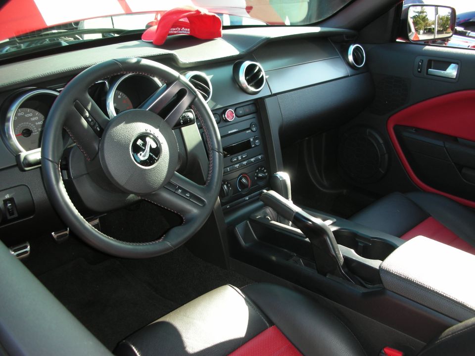 Mustang interior with black and red seats, branded steering wheel and console
