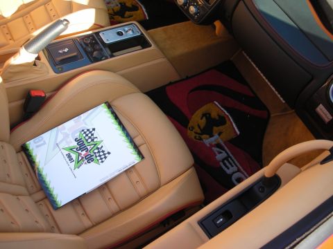 1998 Ford Crown Victoria - Tan leather sports car cabin with a logo floor mat and an event program resting on the passenger seat.