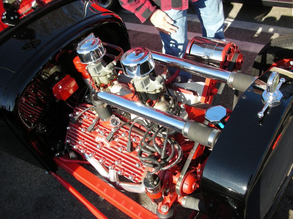 Chromed V8 engine with dual carburetors and finned valve covers in a hot rod