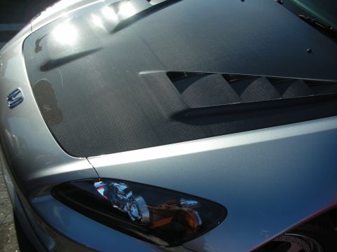 1998 Ford Crown Victoria - silver sports car photographed from above showing a black vented hood section and the clear right headlight assembly.