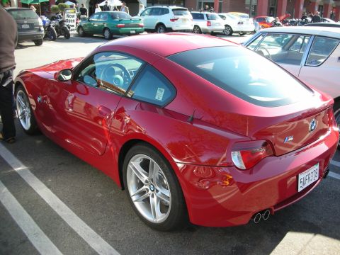 1998 Ford Crown Victoria - red BMW Z4 coupe shown from the rear three-quarter, with twin exhaust tips and a California license plate.