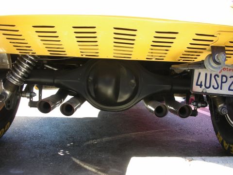 1998 Ford Crown Victoria - Underbody view of a yellow car showing the rear differential, side exhaust pipes and a partial plate reading 4USP2.