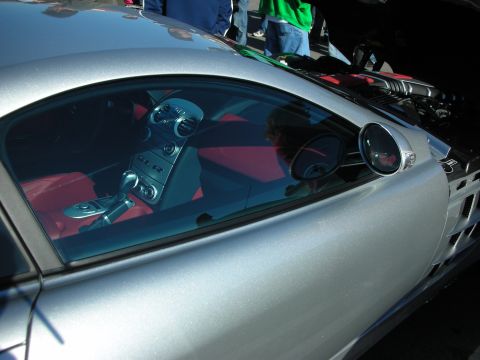 1998 Ford Crown Victoria - Looking through the side glass of a silver Mercedes SLR McLaren into its red leather cabin and side mirror.
