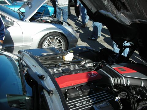 1998 Ford Crown Victoria - engine of a silver Mercedes SLR with SLR script on the cover and red detailing, a silver coupe parked behind it.