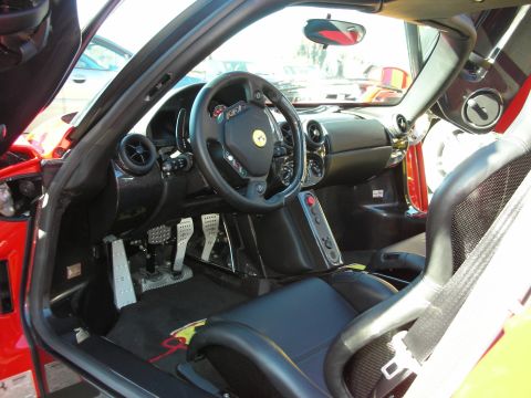1998 Ford Crown Victoria - black interior of a Ferrari Enzo with a yellow-badged steering wheel, drilled alloy pedals, and exposed shift gate.