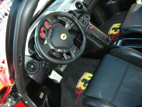 1998 Ford Crown Victoria - Ferrari cockpit with red-faced gauges, carbon-fiber trim, and black floor mats embroidered with yellow prancing-horse logos.