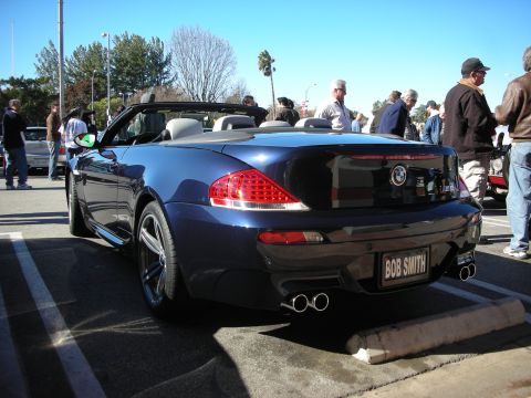 1998 Ford Crown Victoria - rear of a dark blue BMW M6 convertible with quad exhaust tips, parked in a lot with a BOB SMITH dealer plate.